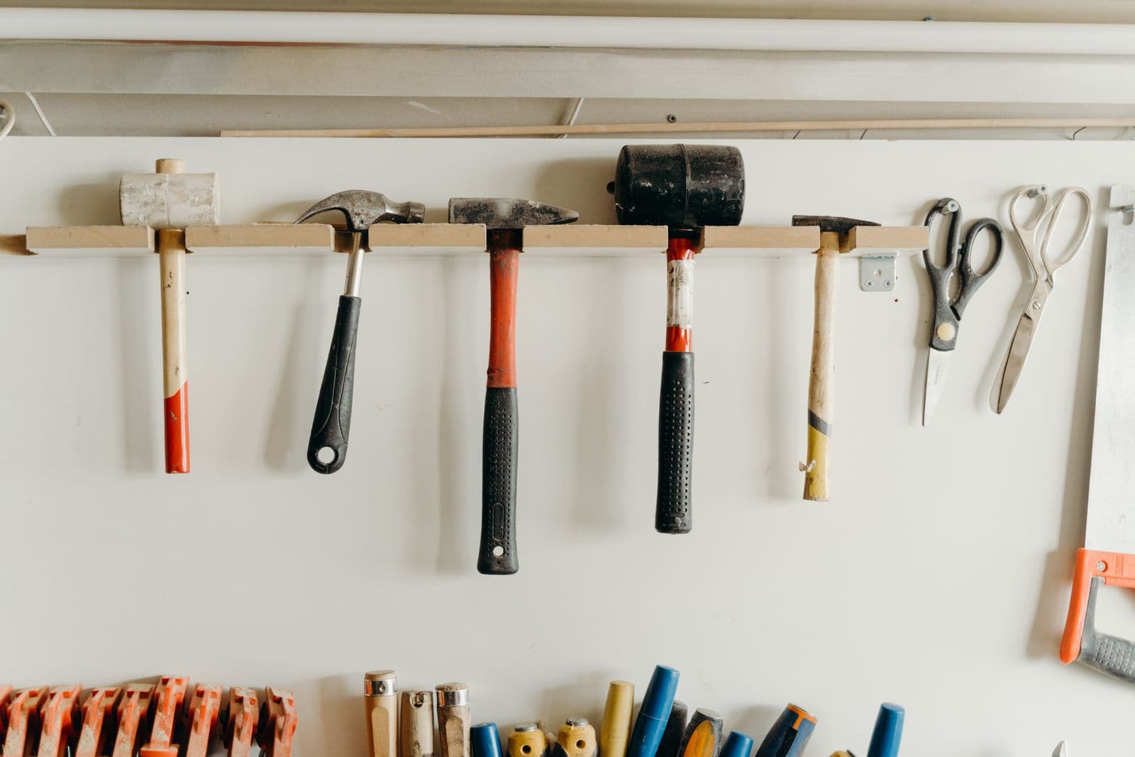 Wand met opgehangen hamers en ander handgereedschap