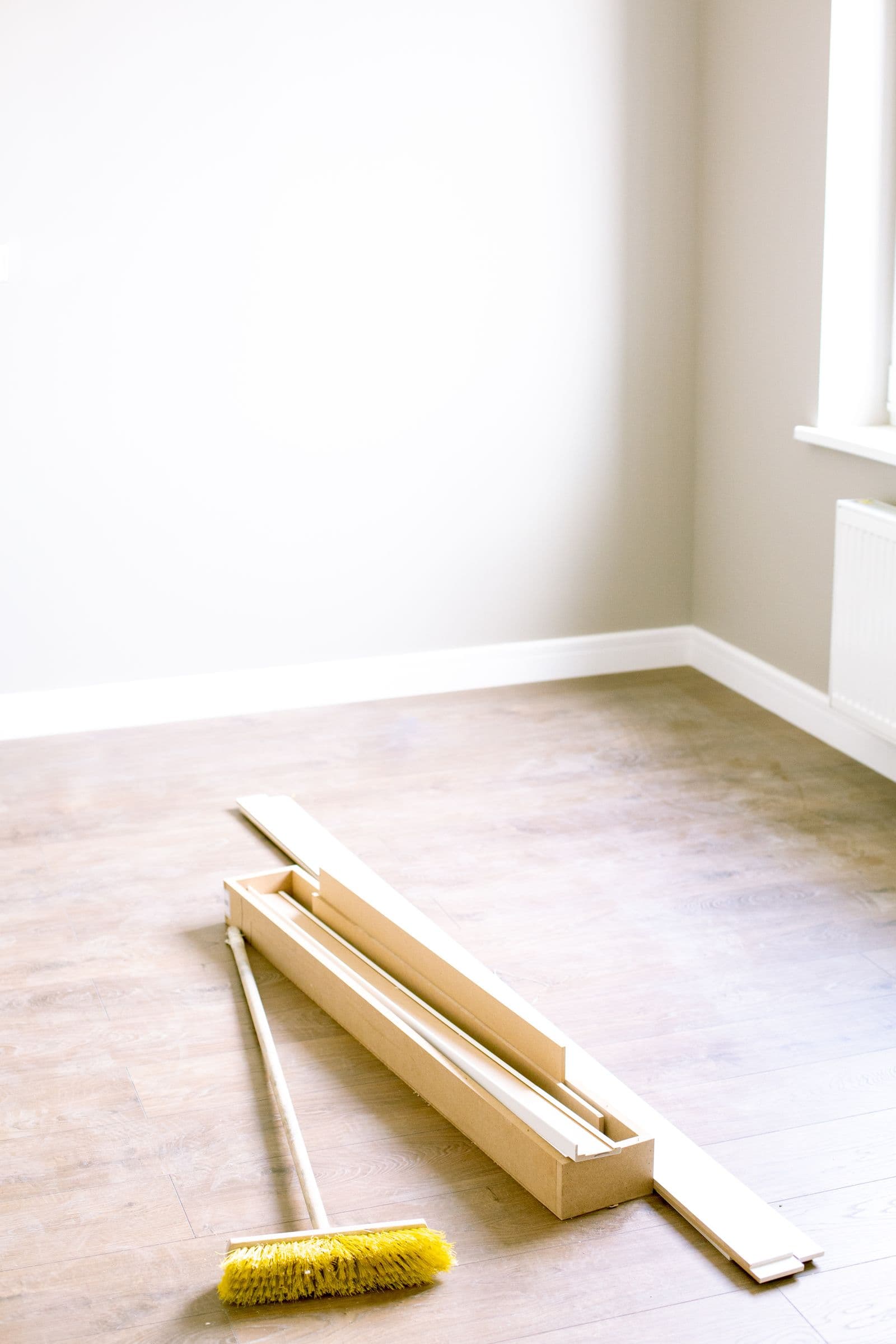Lege kamer met houten vloerdelen, klaar voor renovatie